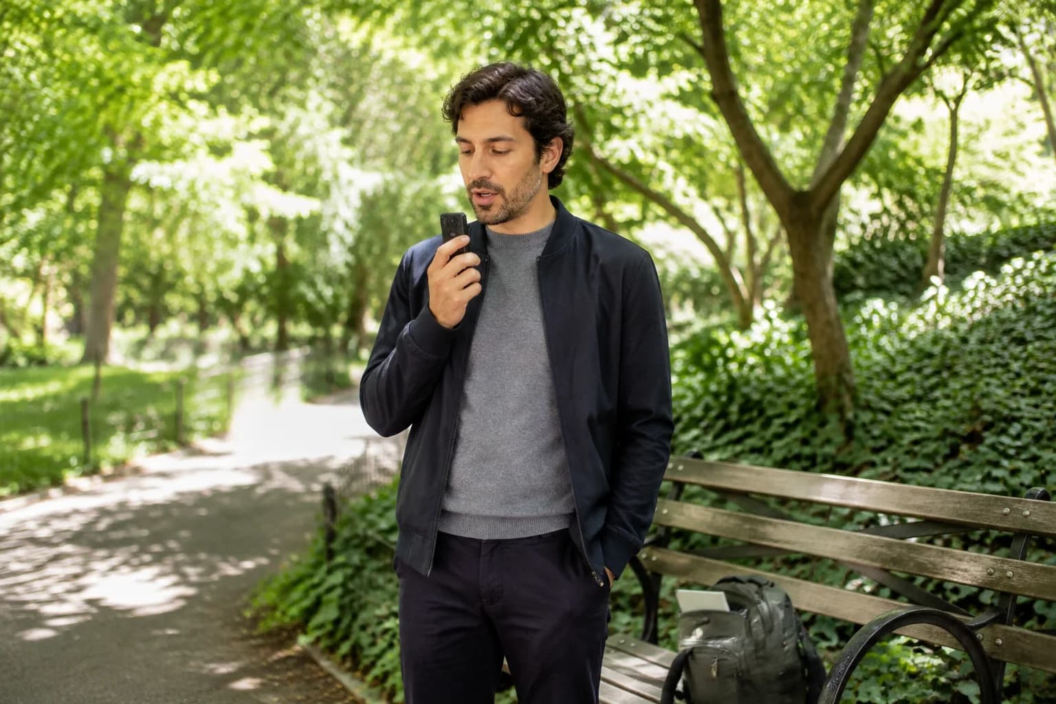 A learner recording a spoken reply beside a park bench