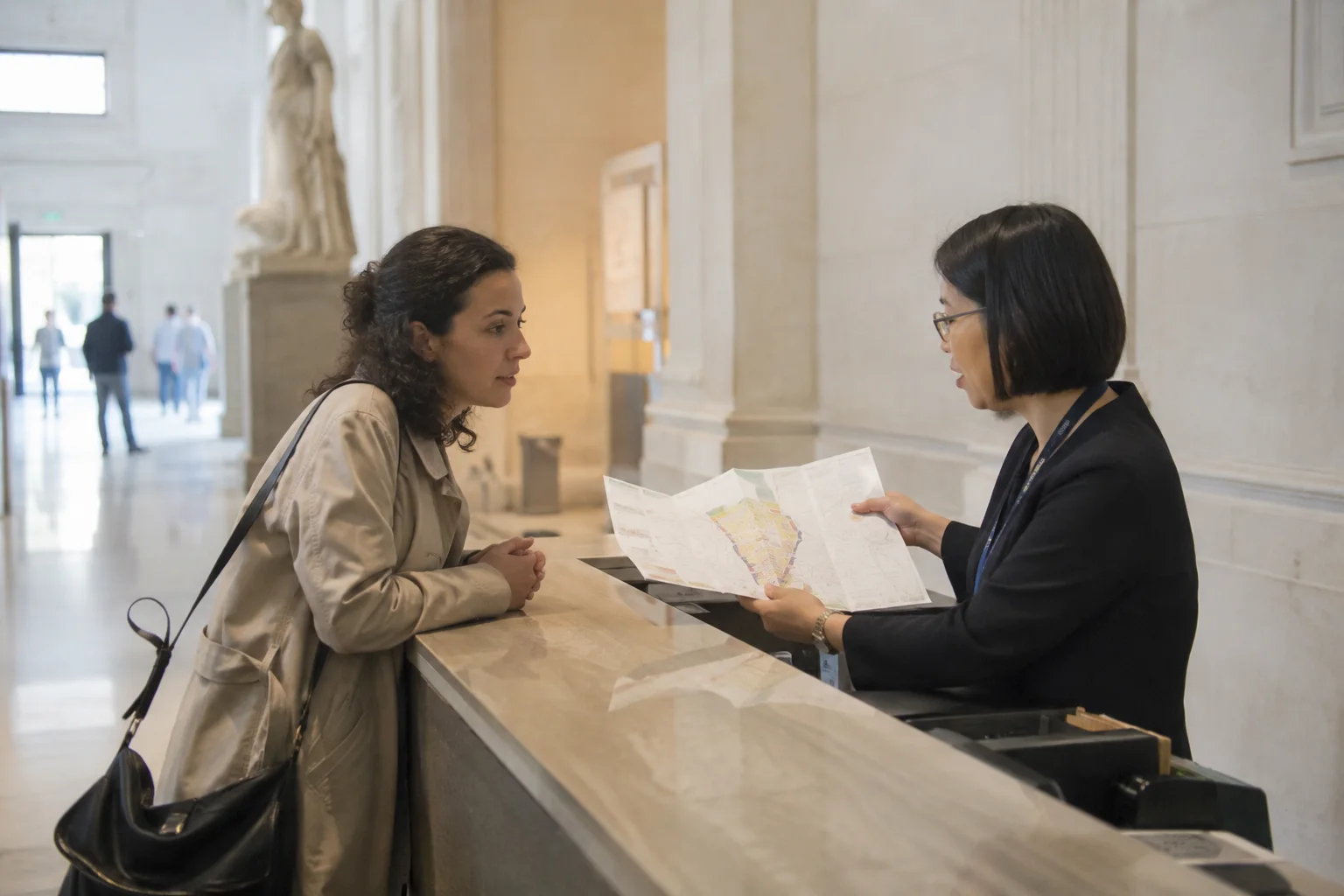 A visitor listens to a museum employee explaining a floor plan
