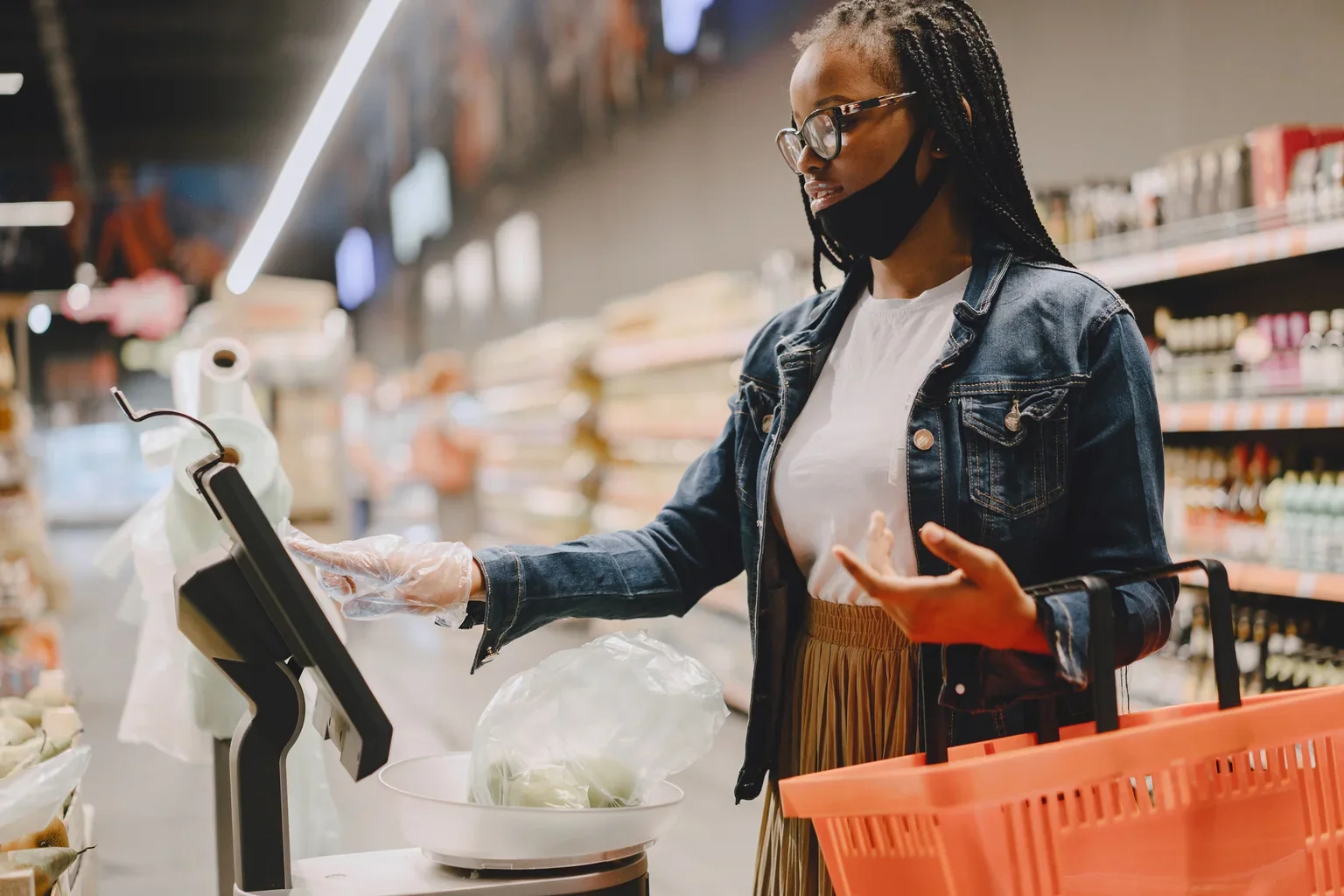 A shopper using a produce scale in a supermarket.