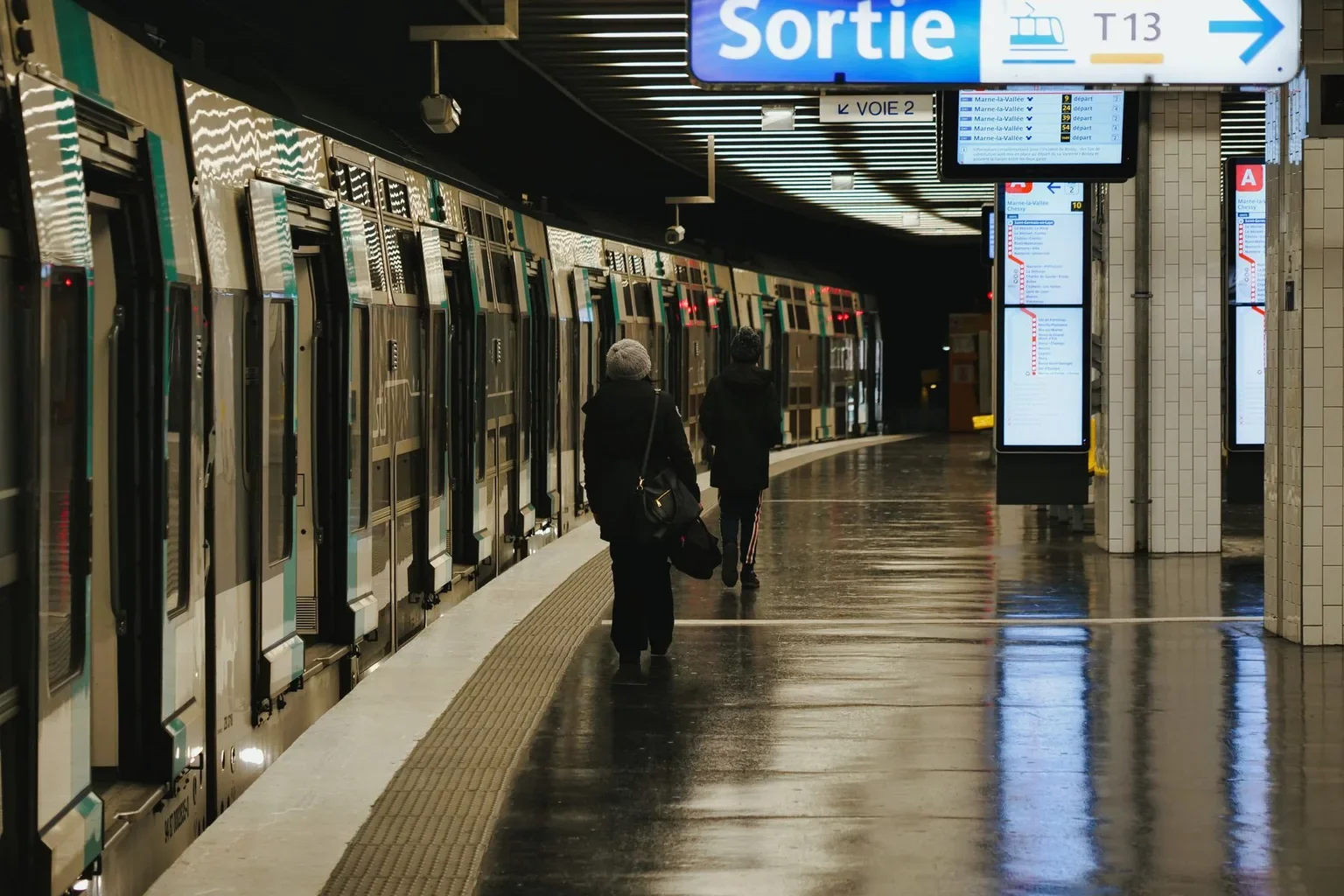 A platform and signs inside a Paris Métro station