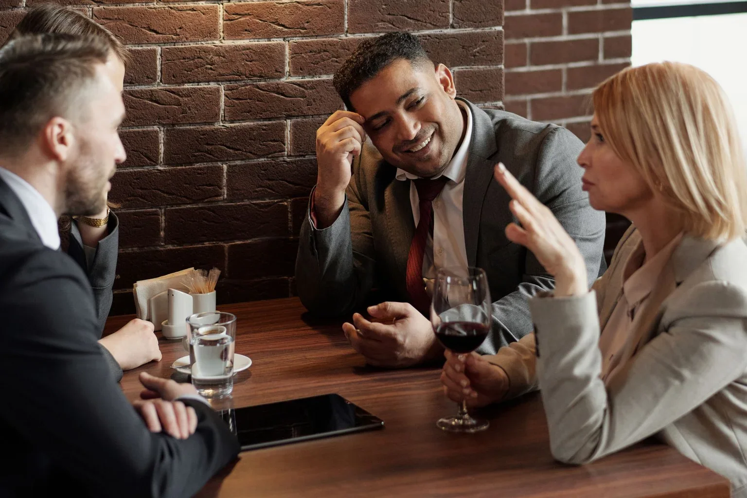 Colleagues talking together over drinks at a café table